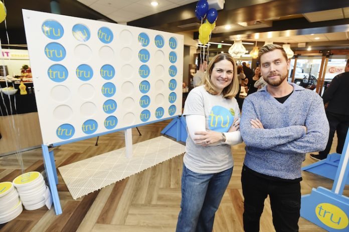 NSYNC member Lance Bass and Alexandra Jaritz, SVP and global head, Tru by Hilton, celebrate Tru by Hilton's growth to 50 open hotels with a giant CONNECT 4 tournament at Tru by Hilton Salt Lake City Airport. (Photo by Fred Hayes/Getty Images for Tru by Hilton)