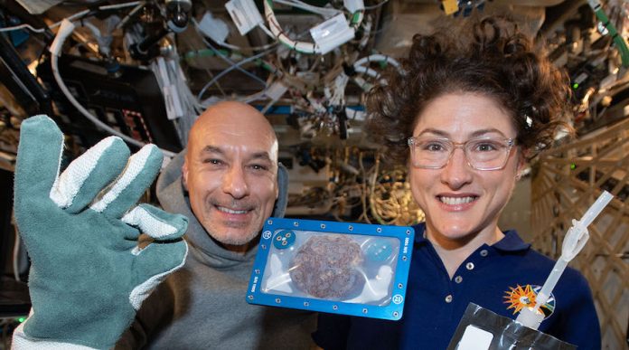 ISS Commander Luca Parmitano of the European Space Agency and NASA astronaut Christina Koch with DoubleTree cookies