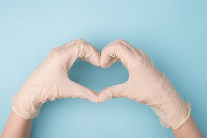 gloved hands form a heart