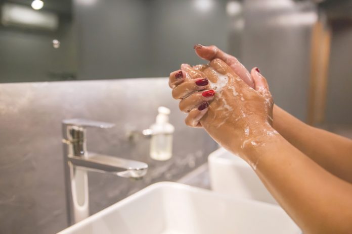 woman washing hands in restroom