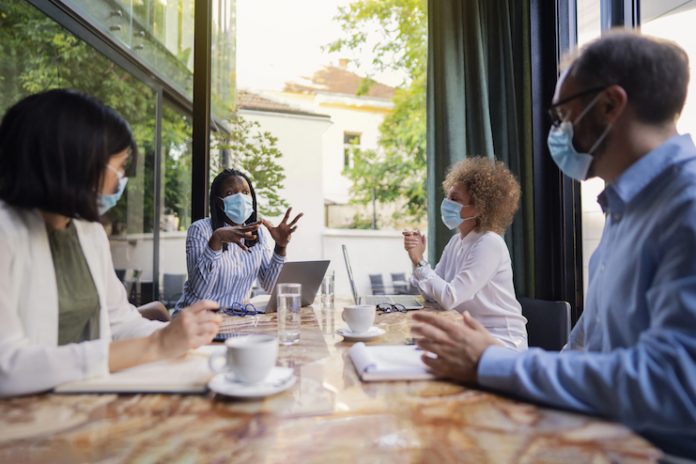 Small meeting outside with attendees wearing face masks